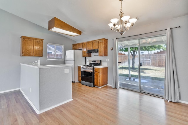 1226 Summer Field Dr, Hanford, CA 93230 - kitchen with stainless steel range, under cabinet range hood, freestanding refrigerator, a chandelier, and lofted ceiling
