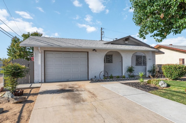 4003 E El Monte Way, Fresno, CA 93702 - view of front of property with concrete driveway, stucco siding, an attached garage, and roof with shingles