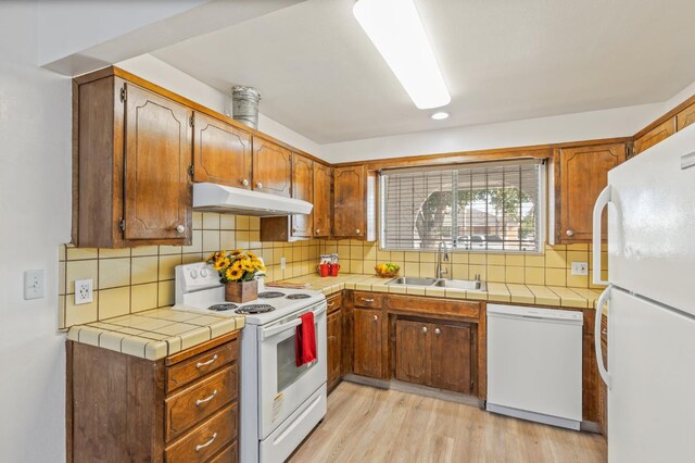 4003 E El Monte Way, Fresno, CA 93702 - kitchen featuring white appliances, under cabinet range hood, a sink, backsplash, and light wood-style floors