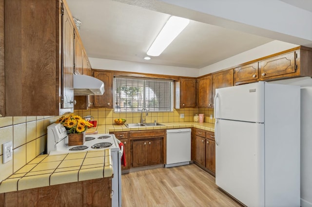 4003 E El Monte Way, Fresno, CA 93702 - kitchen with white appliances, a sink, under cabinet range hood, tile counters, and light wood-type flooring