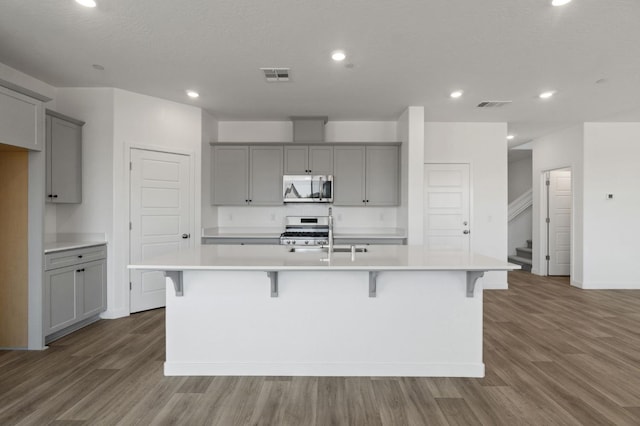 3210 Frontera Ave, Clovis, CA 93619 - kitchen with gray cabinets, a sink, stainless steel range with gas cooktop, an island with sink, and recessed lighting