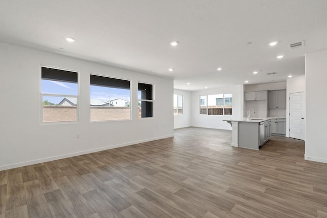 3210 Frontera Ave, Clovis, CA 93619 - unfurnished living room with recessed lighting, light wood-style flooring, a sink, and baseboards