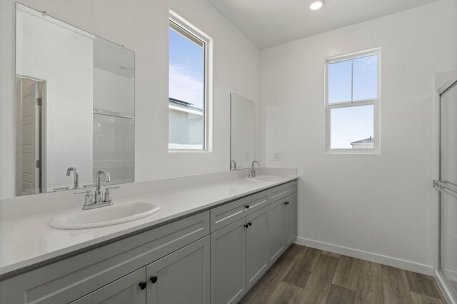 3210 Frontera Ave, Clovis, CA 93619 - full bath with wood finished floors, double vanity, baseboards, and a shower with shower door