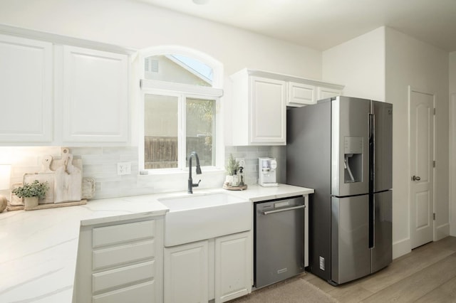 578 W Serena Ave, Clovis, CA 93619 - kitchen with appliances with stainless steel finishes, decorative backsplash, white cabinets, light stone counters, and light wood-type flooring