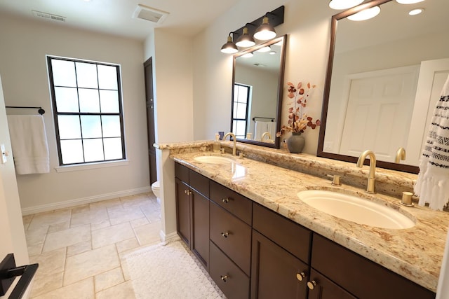 2210 W Spruce Ave, Fresno, CA 93711 - bathroom with double vanity, plenty of natural light, toilet, and baseboards