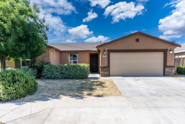 5576 E Burns Ave, Fresno, CA 93727 - single story home with stucco siding, an attached garage, stone siding, and driveway