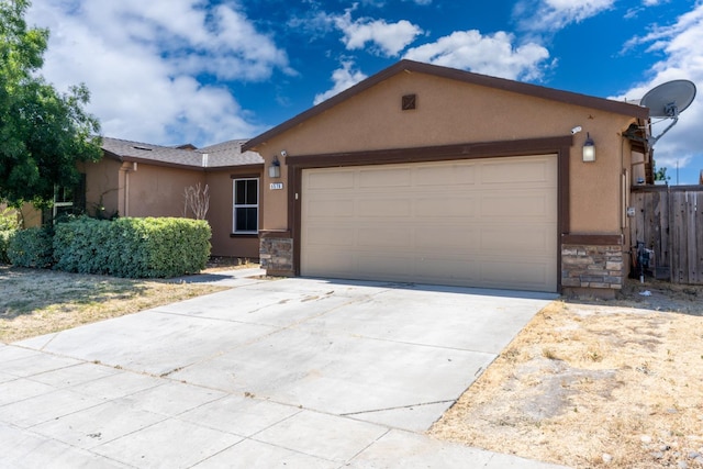 5576 E Burns Ave, Fresno, CA 93727 - view of front of home featuring stone siding, stucco siding, a garage, and concrete driveway