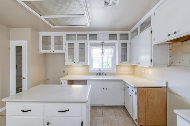 724 W Harvard Ave, Fresno, CA 93705 - kitchen featuring a sink, light tile patterned flooring, glass insert cabinets, white cabinets, and a center island