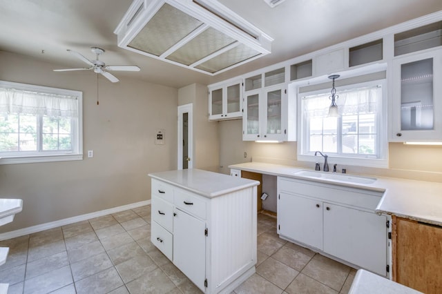 724 W Harvard Ave, Fresno, CA 93705 - kitchen with a sink, ceiling fan, light tile patterned floors, a kitchen island, and white cabinets