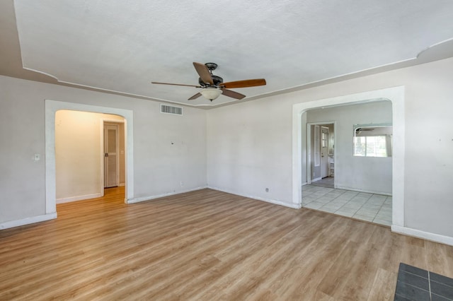 724 W Harvard Ave, Fresno, CA 93705 - spare room featuring a ceiling fan, arched walkways, light wood-style flooring, and baseboards