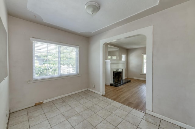 724 W Harvard Ave, Fresno, CA 93705 - empty room with plenty of natural light, baseboards, a tile fireplace, and light tile patterned floors