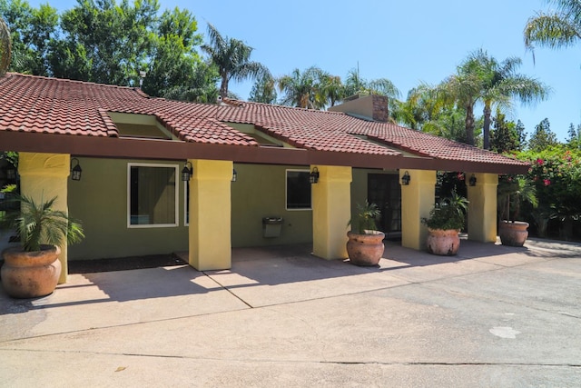 2881 E Huntington Blvd Unit 230, Fresno, CA 93721 - rear view of house with stucco siding, a tile roof, a chimney, and a patio area