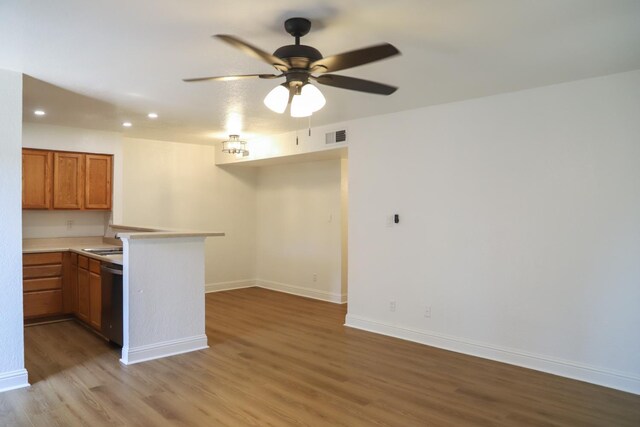 2881 E Huntington Blvd Unit 230, Fresno, CA 93721 - kitchen with a peninsula, light wood-style flooring, open floor plan, baseboards, and brown cabinets