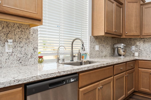 2027 N Bliss Ave, Fresno, CA 93727 - kitchen featuring stainless steel dishwasher, backsplash, light stone countertops, and brown cabinetry