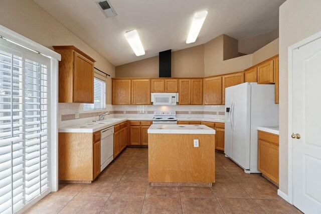 2841 E Brandon Ln, Fresno, CA 93720 - kitchen featuring white appliances, a kitchen island, tasteful backsplash, vaulted ceiling, and light tile patterned floors