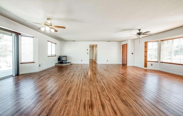 42485 John Muir Dr, Coarsegold, CA 93614 - unfurnished living room with ceiling fan, wood finished floors, and a wood stove