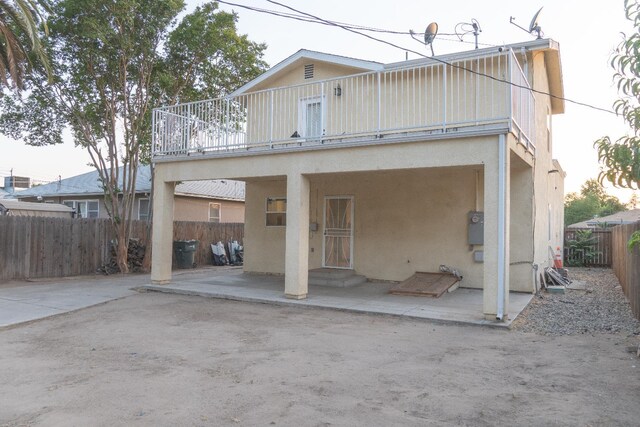2048 N Arthur Ave, Fresno, CA 93705 - back of property featuring a fenced backyard, stucco siding, a patio area, and a balcony