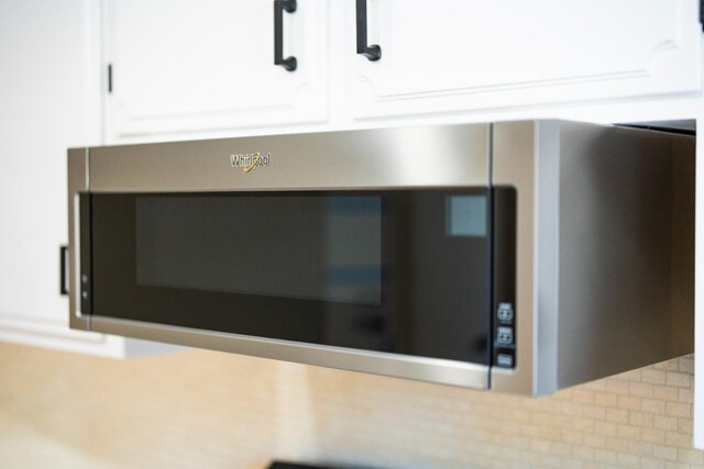 1707 Douglas Ave, Clovis, CA 93611 - kitchen view of stainless steel microwave, white cabinetry, and decorative backsplash