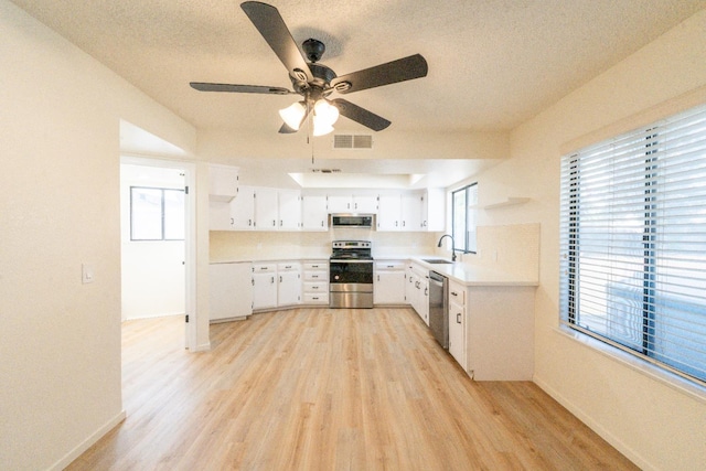 1707 Douglas Ave, Clovis, CA 93611 - kitchen with appliances with stainless steel finishes, a sink, light wood-style floors, light countertops, and a textured ceiling