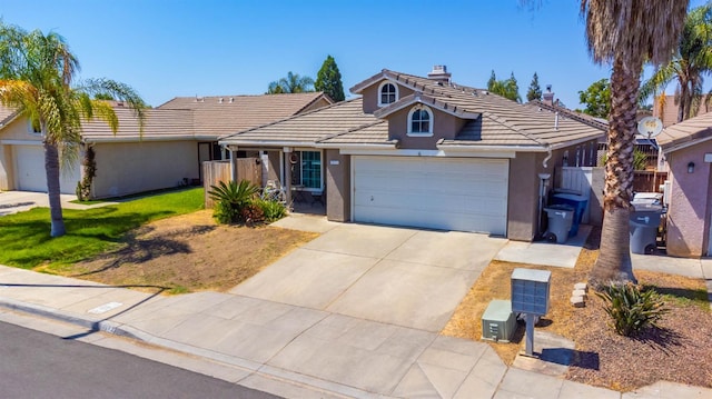 5572 W Indianapolis Ave, Fresno, CA 93722 - single story home with a garage, a tile roof, a chimney, concrete driveway, and stucco siding
