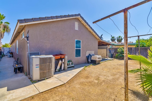 5572 W Indianapolis Ave, Fresno, CA 93722 - rear view of house with central AC unit, stucco siding, and a fenced backyard