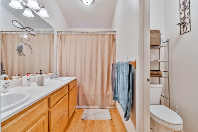 5572 W Indianapolis Ave, Fresno, CA 93722 - full bath featuring wood finished floors, toilet, double vanity, and a shower with shower curtain