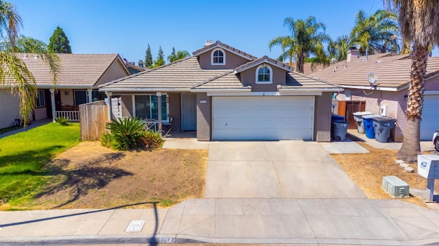 5572 W Indianapolis Ave, Fresno, CA 93722 - view of front of house featuring a garage, concrete driveway, a tiled roof, and stucco siding