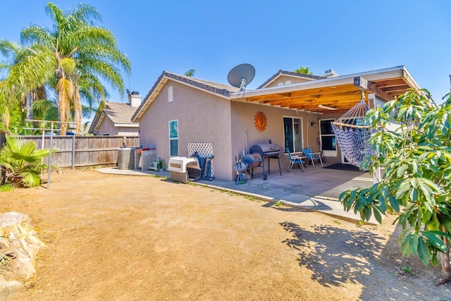 5572 W Indianapolis Ave, Fresno, CA 93722 - rear view of house with stucco siding and a patio