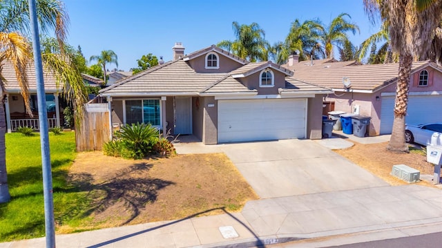 5572 W Indianapolis Ave, Fresno, CA 93722 - view of front of house featuring stucco siding, an attached garage, concrete driveway, a tile roof, and a chimney