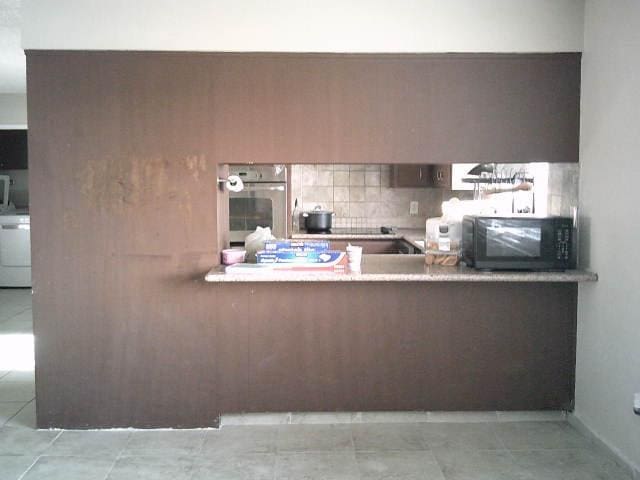 582 N Academy Ave, Sanger, CA 93657 - kitchen featuring black microwave, stainless steel oven, backsplash, dishwasher, and a peninsula