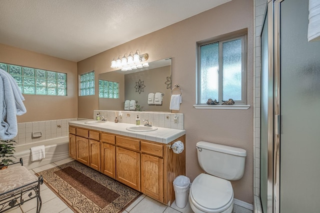 41228 Heartwood Ln, Shaver Lake, CA 93664 - bathroom featuring tile patterned floors, double vanity, toilet, a bath, and a textured ceiling