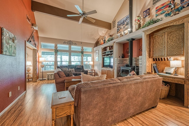 41228 Heartwood Ln, Shaver Lake, CA 93664 - living room with a wood stove, a ceiling fan, light wood-style flooring, high vaulted ceiling, and baseboards