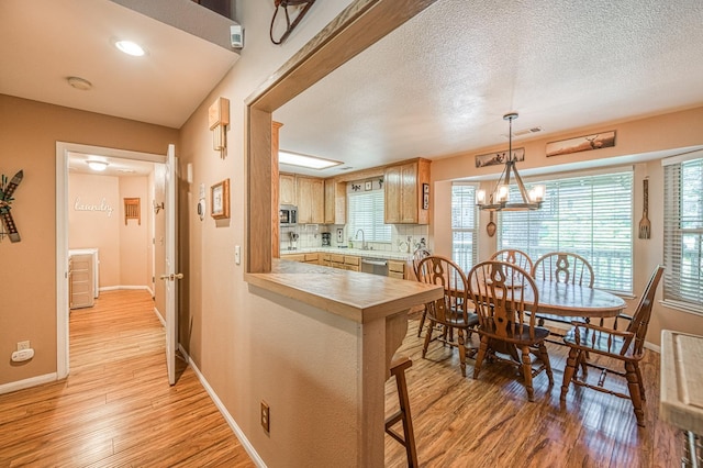 41228 Heartwood Ln, Shaver Lake, CA 93664 - kitchen featuring stainless steel appliances, light wood-style flooring, a sink, and a textured ceiling