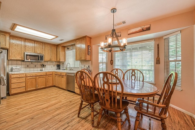 41228 Heartwood Ln, Shaver Lake, CA 93664 - dining area with a chandelier, light wood-type flooring, and baseboards