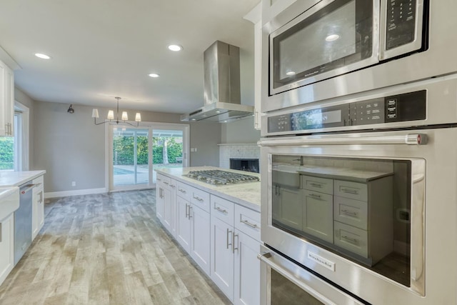 1463 W San Madele Ave, Fresno, CA 93711 - kitchen with stainless steel appliances, range hood, white cabinetry, a chandelier, and recessed lighting