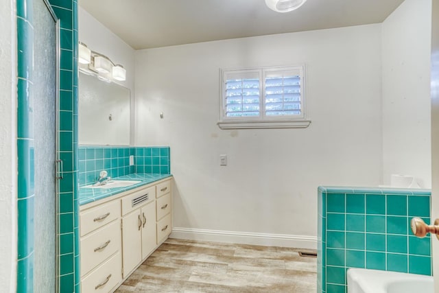 1463 W San Madele Ave, Fresno, CA 93711 - full bath with wood finished floors, vanity, decorative backsplash, a bathtub, and baseboards
