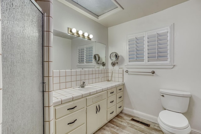 1463 W San Madele Ave, Fresno, CA 93711 - full bathroom with tasteful backsplash, vanity, wood finished floors, baseboards, and toilet