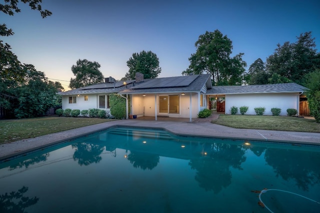 1463 W San Madele Ave, Fresno, CA 93711 - back of house with solar panels, an outdoor pool, a patio area, a chimney, and stucco siding