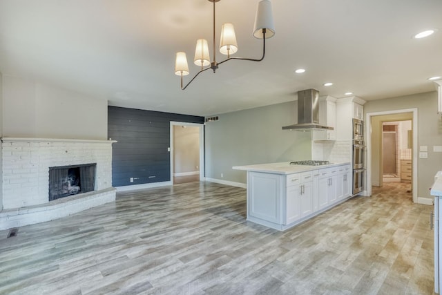1463 W San Madele Ave, Fresno, CA 93711 - kitchen featuring wall chimney range hood, baseboards, appliances with stainless steel finishes, white cabinets, and recessed lighting