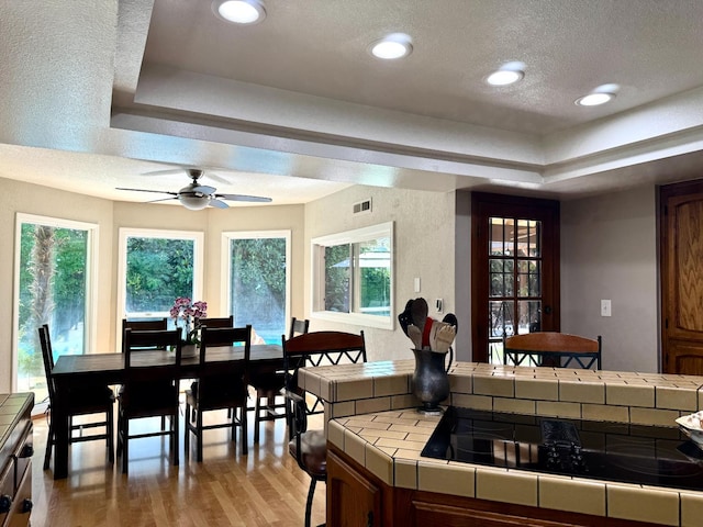 8866 N Ione Ave, Fresno, CA 93720 - dining space featuring a tray ceiling, light wood finished floors, healthy amount of natural light, recessed lighting, and a textured ceiling