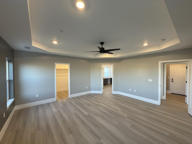 21275 Rd 28 Unit 1 2, Madera, CA 93638 - unfurnished bedroom with a tray ceiling, baseboards, light wood-style flooring, a spacious closet, and recessed lighting