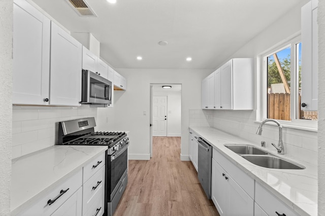 2543 E Ashcroft Ave, Fresno, CA 93726 - kitchen with stainless steel appliances, a sink, light stone countertops, recessed lighting, and light wood-style floors