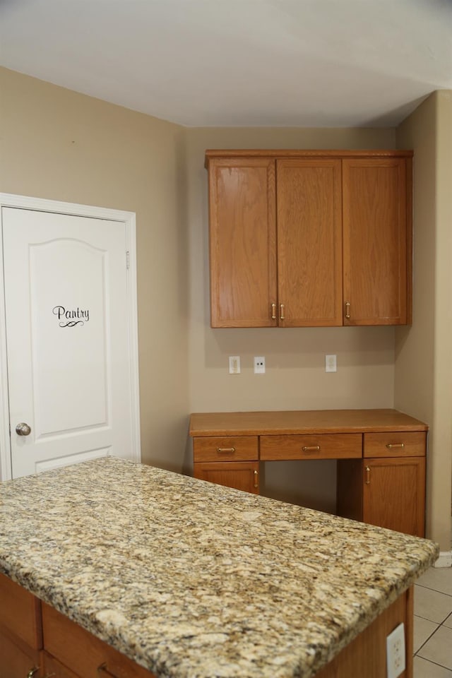 5811 W Cromwell Ave, Fresno, CA 93722 - kitchen with light tile patterned flooring, light stone countertops, and brown cabinets