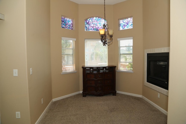 5811 W Cromwell Ave, Fresno, CA 93722 - dining room featuring a high ceiling, carpet flooring, baseboards, and a glass covered fireplace