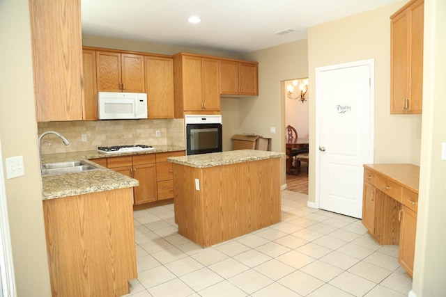 5811 W Cromwell Ave, Fresno, CA 93722 - kitchen featuring white appliances, a sink, decorative backsplash, a kitchen island, and light stone counters
