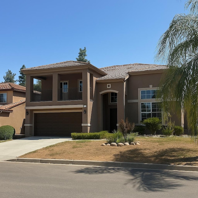 5811 W Cromwell Ave, Fresno, CA 93722 - view of front of property with a garage, stucco siding, a balcony, driveway, and a tile roof