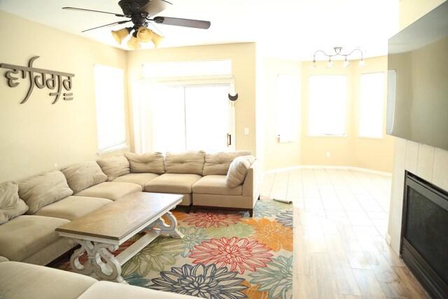 5811 W Cromwell Ave, Fresno, CA 93722 - living area featuring ceiling fan, a fireplace, healthy amount of natural light, and baseboards