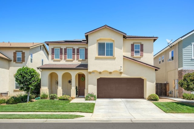 7452 E Giavanna Ave, Fresno, CA 93737 - view of front facade featuring stucco siding, a garage, solar panels, driveway, and a front lawn