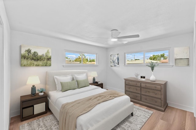 3926 N Kavanagh Ave, Fresno, CA 93705 - bedroom featuring multiple windows, light wood-type flooring, baseboards, and a ceiling fan