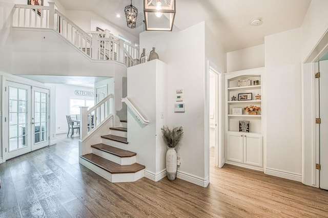 1039 N Burgan Ave, Clovis, CA 93611 - staircase with wood finished floors, baseboards, a chandelier, and french doors